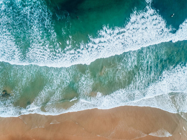 Aerial view of people surfing on a beach in Asturias - Valokuva, kuva