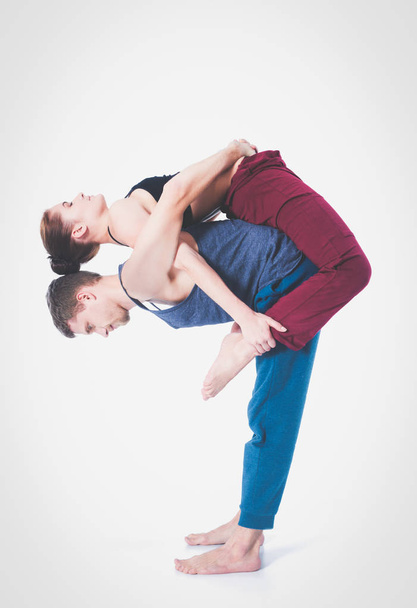 Young athletic couple practicing acroyoga. Balancing in pair. - Zdjęcie, obraz