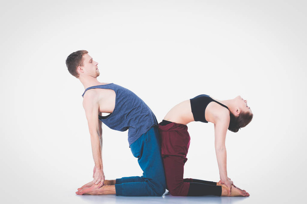 Young athletic couple practicing acroyoga. Balancing in pair. - Foto, Imagem