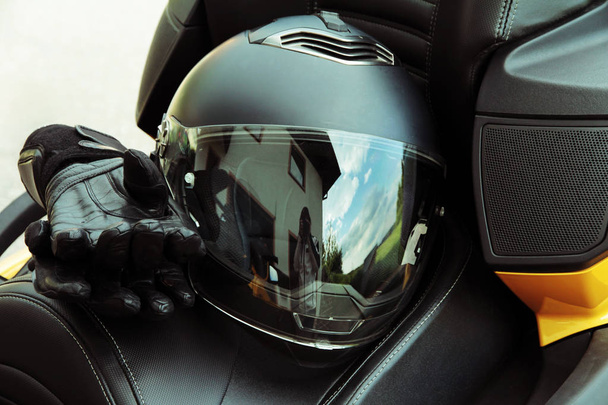 Moottoriurheilun suojavaatteet ja turvallisuus. Moottoripyöräilykypärä ja käsineet
 - Valokuva, kuva