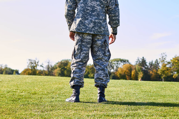 Soldier on the grass, back view. - Φωτογραφία, εικόνα