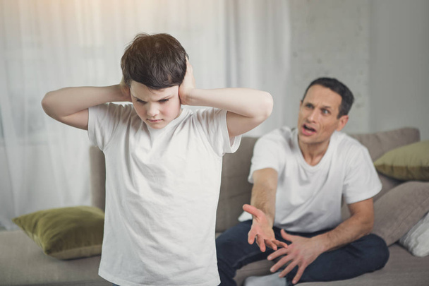 Irritierter Vater schreit seinen Sohn an - Foto, Bild