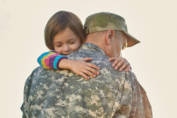 Kleines Kind ist sehr glücklich, dass ihr Vater von der Armee zurückgekehrt ist. - Foto, Bild