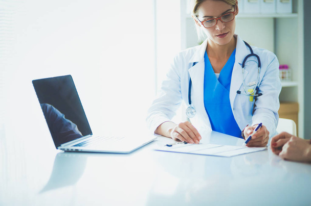 Doctor and patient couple are discussing something,sitting on the desk. - Photo, image