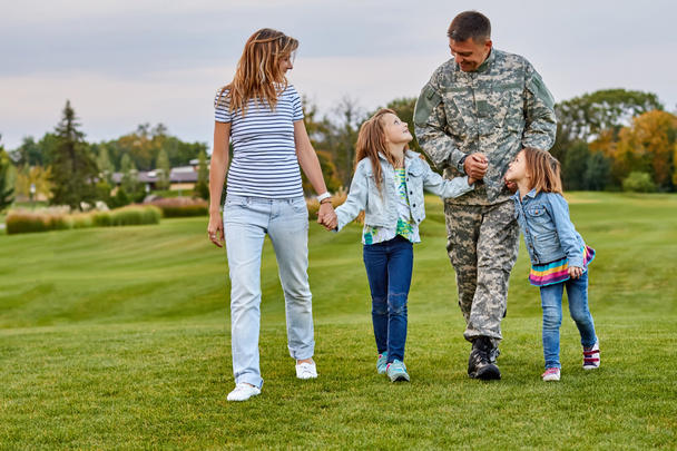 Щаслива сім'я з солдатом батько ходить на відкритому повітрі
. - Фото, зображення