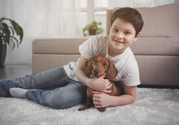 Excited child embracing his favorite domestic pet - Foto, imagen