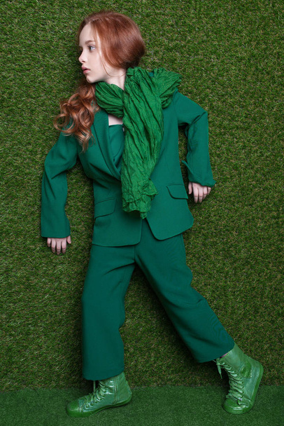 Fashion studio portrait of cute little redhead girl wearing green clothes. - Photo, Image