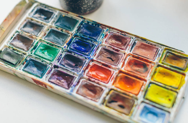 Кисти и краски на столе от художника
 - Фото, изображение