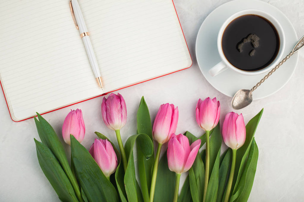 Mulher mesa de trabalho com caneca de café, caderno e primavera tulipa flores vista superior em estilo flat lay
 - Foto, Imagem