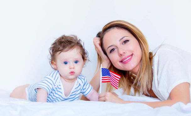 mother and little child boy fith american flag - 写真・画像
