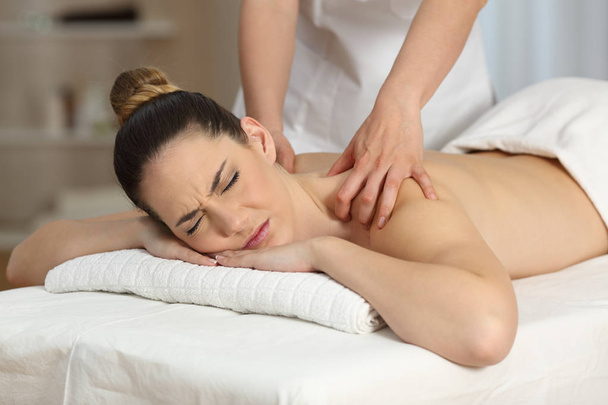 Woman suffering receiving a massage - Foto, Imagen