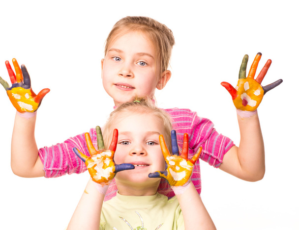 zwei glückliche Mädchen zeigen in leuchtenden Farben bemalte Hände - Foto, Bild
