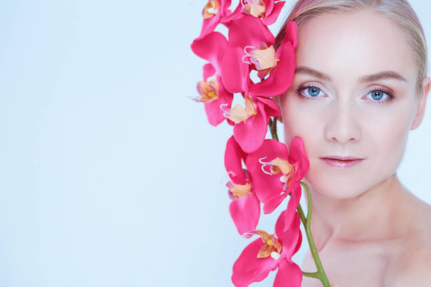 Young beauty woman with flower near face - Fotografie, Obrázek