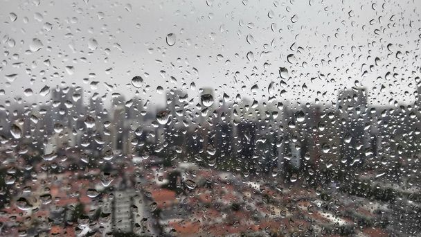 Şehrin bulanık arka plan penceresindeki yağmur damlaları  - Fotoğraf, Görsel