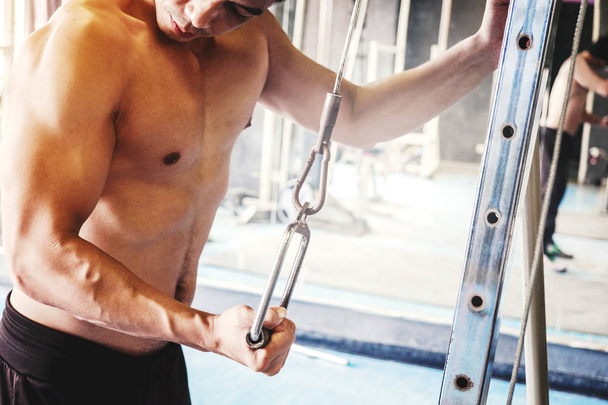 Fitness silný muž dělá těžké hmotnosti cvičení na stroji v posilovně - Fotografie, Obrázek