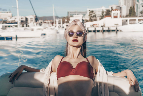 a luxurious rich woman in sunglasses rests and relaxes on her yacht, sails on the Caribbean sea - Fotografie, Obrázek