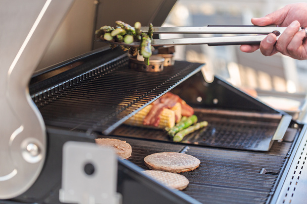 Cocinar hamburguesas en la parrilla de gas al aire libre
  - Foto, imagen