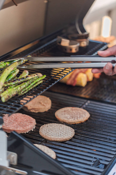 Cooking hamburgers on outdoor gas grill  - Fotó, kép