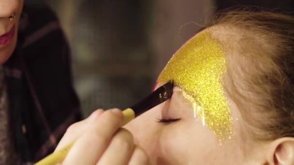 Gesichtskunst. die Maskenbildnerin beim Malen - Filmmaterial, Video