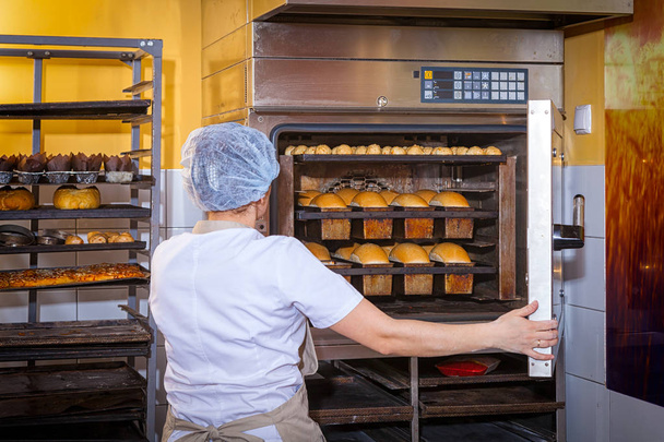 Baker bakes bread - Photo, Image