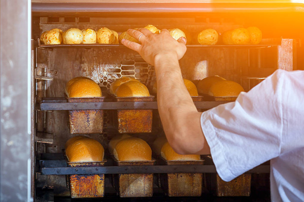 Baker bakes bread - Φωτογραφία, εικόνα