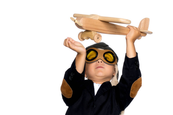 Маленький хлопчик грає з дерев'яним літаком
 - Фото, зображення