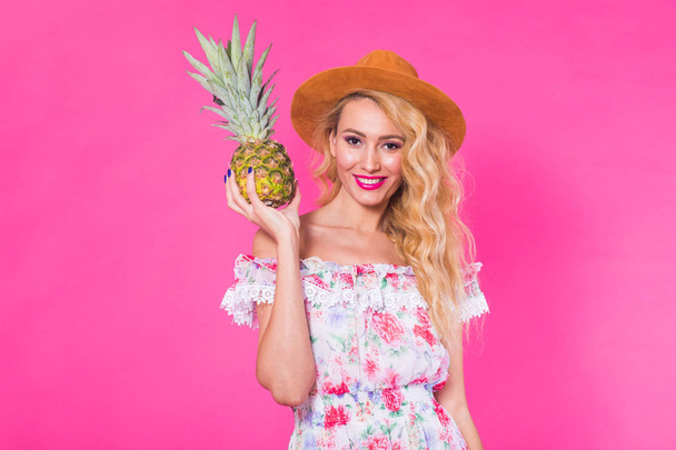 Fashion portrait woman with pineapple over pink background - Valokuva, kuva