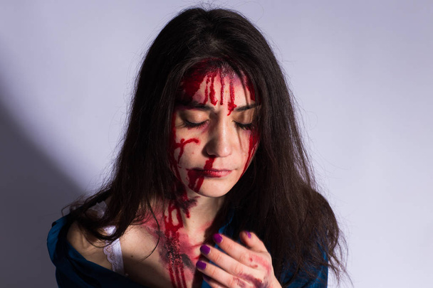 Ξυλοδαρμό νεαρή γυναίκα με μώλωπες και το αίμα στο πρόσωπό της. Κακοποίηση και τη βία έννοια - Φωτογραφία, εικόνα