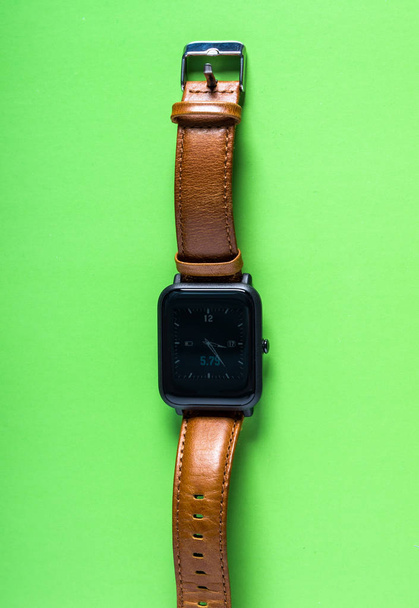 パステル背景色の革ストラップとのスマートな腕時計 - 写真・画像