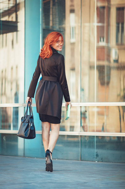 femme d'affaires souriante marchant sur le chemin dans l'immeuble de bureaux
 - Photo, image
