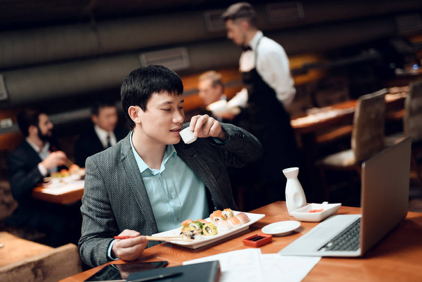 Man on drinking coffee on meeting with Chinese businessmen in restaurant - 写真・画像