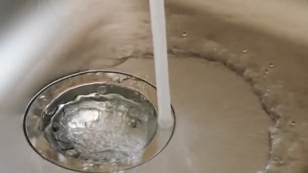 L'acqua da un rubinetto riempie un lavandino di cucina
. - Filmati, video