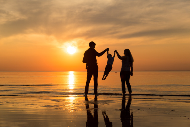 famille sur la plage au coucher du soleil - Photo, image