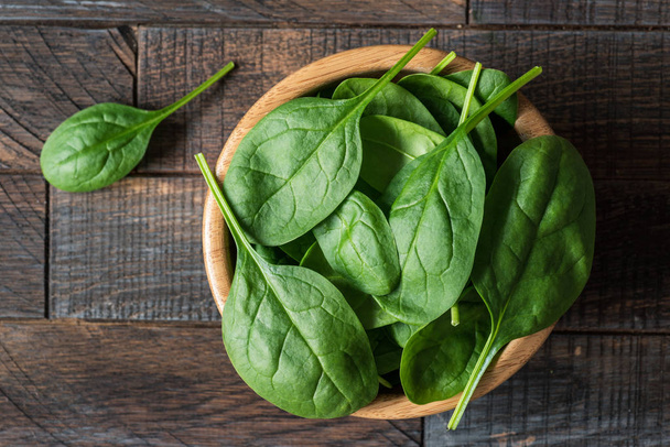 Baby spinach in wooden bowl - Foto, afbeelding