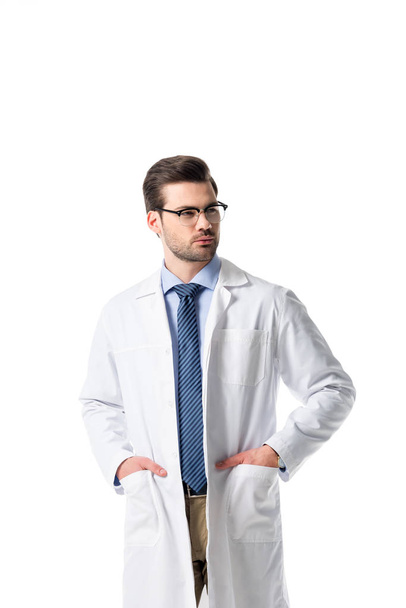 Confident male doctor wearing white coat isolated on white - Фото, изображение