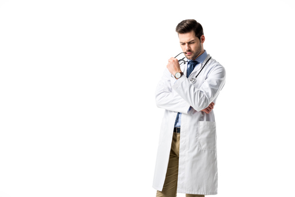 Médecin réfléchi portant un manteau blanc avec stéthoscope isolé sur blanc
 - Photo, image