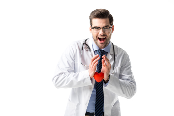 Iloinen lääkäri yllään valkoinen takki stetoskooppi ja pitämällä lelu sydän eristetty valkoinen
 - Valokuva, kuva