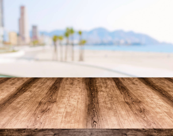 Tavolino vuoto in legno davanti a sfondo sfocato. Può essere
  - Foto, immagini