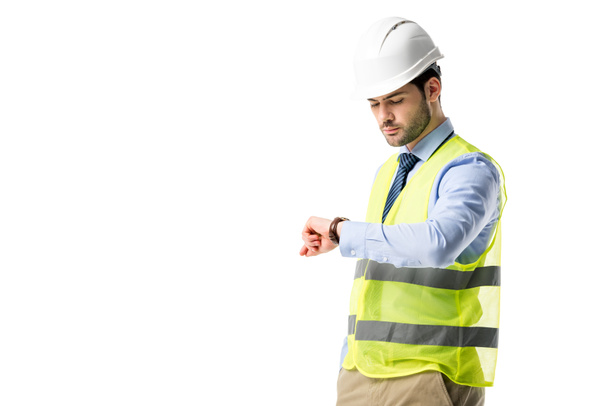 Bouwvakker in reflecterend vest controleren zijn horloge geïsoleerd op wit - Foto, afbeelding