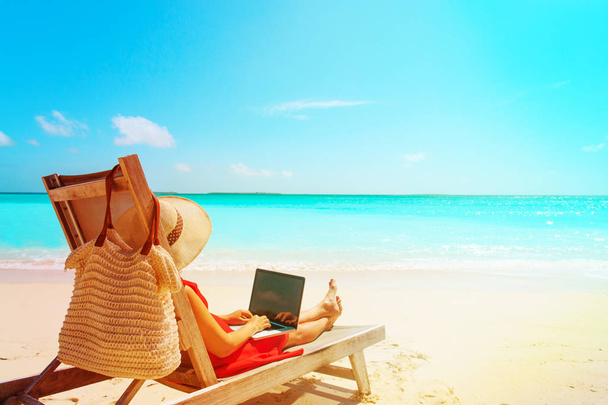 távoli munka fogalma-fiatal nő, laptop, a strandon - Fotó, kép