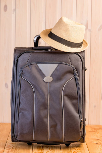 Valmis pakattu täytetty matkalaukku ja top of että olki tyylikäs hattu
  - Valokuva, kuva