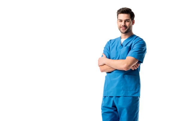 Νοσοκόμος φορώντας μπλε στολή στέκεται με σταυρωμένα τα όπλα απομονωθεί σε λευκό - Φωτογραφία, εικόνα