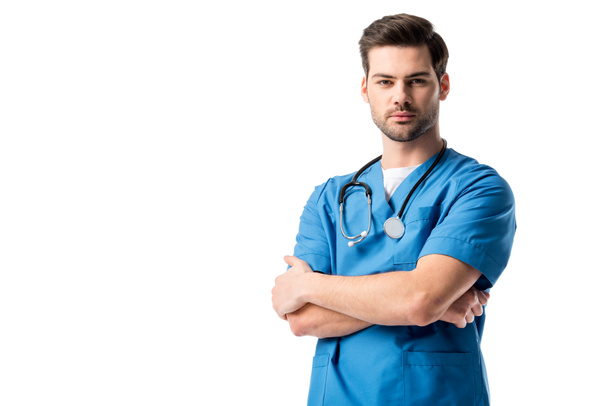 Chirurgo in uniforme blu con stetoscopio in piedi con braccia incrociate isolate su bianco
 - Foto, immagini