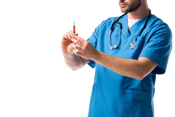 Szczegół widok strzykawki w rękach pielęgniarz sobie jednolity niebieski z stetoskop na białym tle - Zdjęcie, obraz