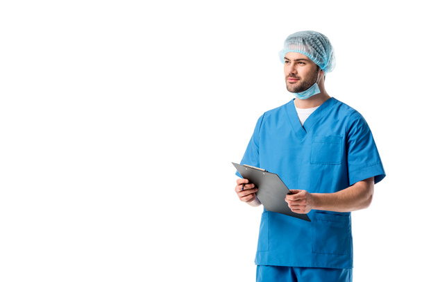 Chirurg na sobie niebieski mundur i pisania diagnozy w schowku na białym tle - Zdjęcie, obraz