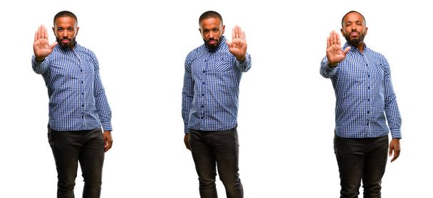Hombre afroamericano con barba molesto con mala actitud haciendo señal de stop con la mano, diciendo no, expresando seguridad, defensa o restricción, tal vez empujando
 - Foto, imagen