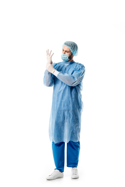 Surgeon in blue uniform wearing medical gloves isolated on white - Photo, Image