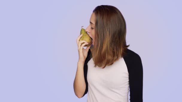 Beautiful woman holds fresh tasty pear - Imágenes, Vídeo