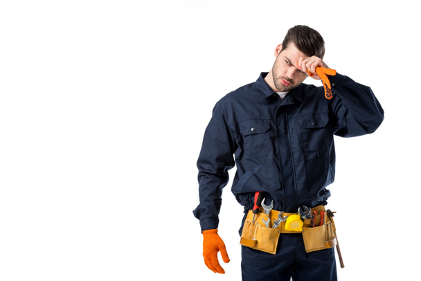 portrait of tired plumber in uniform and protective gloves looking away isolated on white - Photo, Image