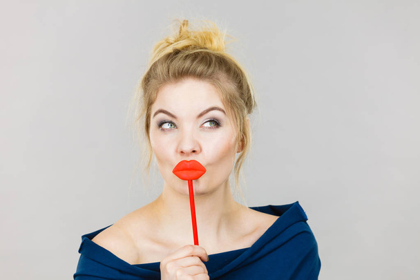 Funny woman holding big red lips on stick - Foto, Bild
